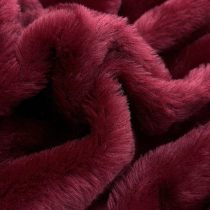 Muestra de tela peluche color bordó, textura de pelo.
