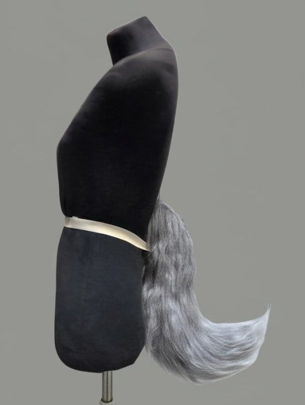 Cola de fursuit gris, vista de perfil sobre maniquí.