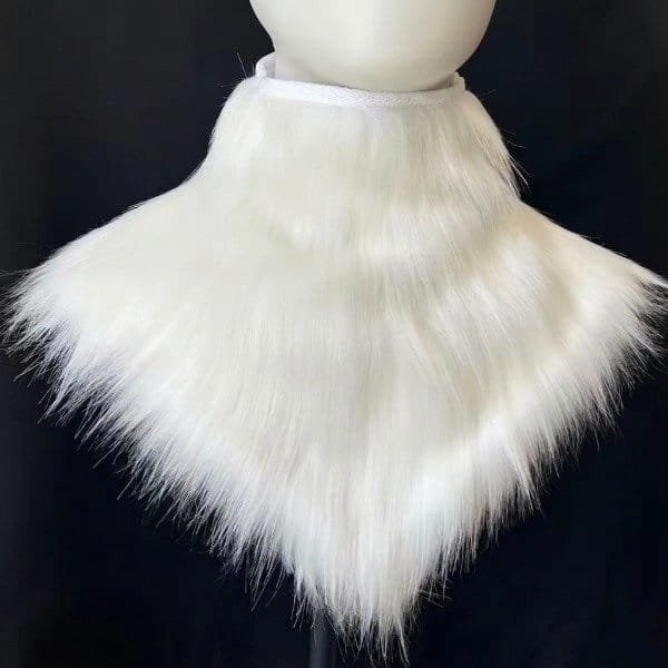 Cuello de pelo blanco sobre maniquí, fondo negro.