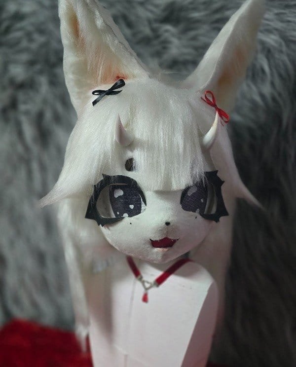Cabeza de fursuit blanca tipo zorro espiritual, vista lateral mostrando las orejas y el largo del pelaje.